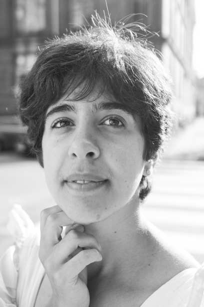 在哥本哈根阳光普照的街道上，一个穿着黄色连衣裙的短发女孩图片下载