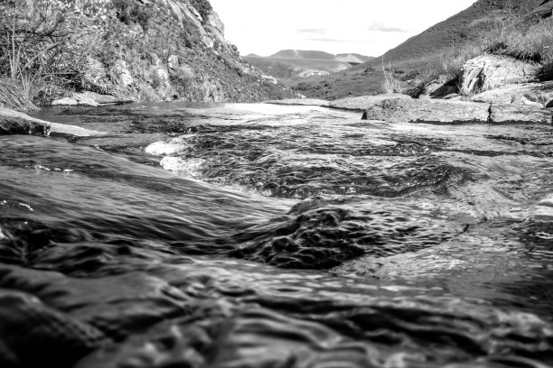 在南非德拉肯斯堡山脉的偏远地区，从悬崖边缘的一条小溪上俯瞰，就在它落下之前，黑白照片。图片下载