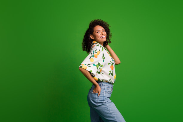 照片积极开朗的女孩站着摆姿势看空的空间在精品店提供孤立的生动的色彩背景图片下载