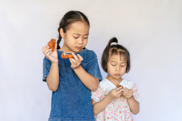 两名亚洲女孩吃炸鸡的特写图片下载