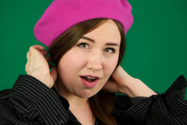 年轻的法国风格的女人的肖像女人在绿色的背景上，chromakey在一个黑色条纹的男人衬衫不同的情绪面部表情特写广告空间为文字清洁。善良的眼睛图片下载