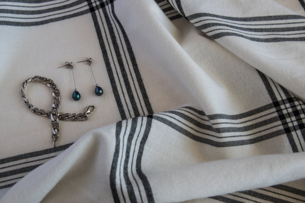 棉质织物或布质纺织品与笼和银耳环手镯。图片下载