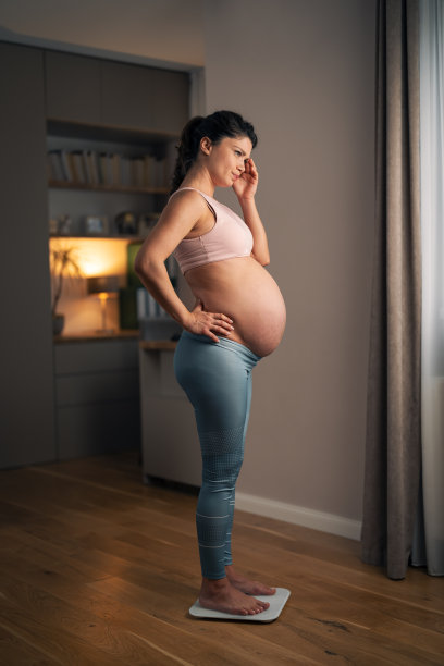 一名成年孕妇在测量体重时陷入沉思的全长照片图片下载