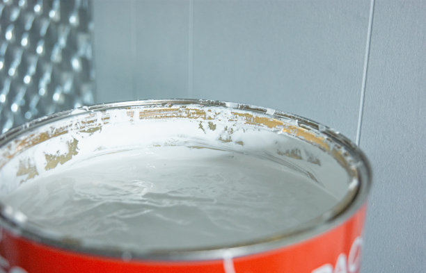 这张照片描绘了一个装满白色油漆的大桶。图片下载