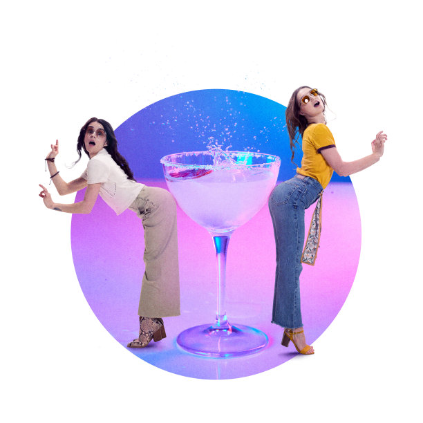 当代艺术拼贴。两个女人站在一杯酸甜鸡尾酒旁，在五彩缤纷的背景下开玩笑地摆姿势。图片下载