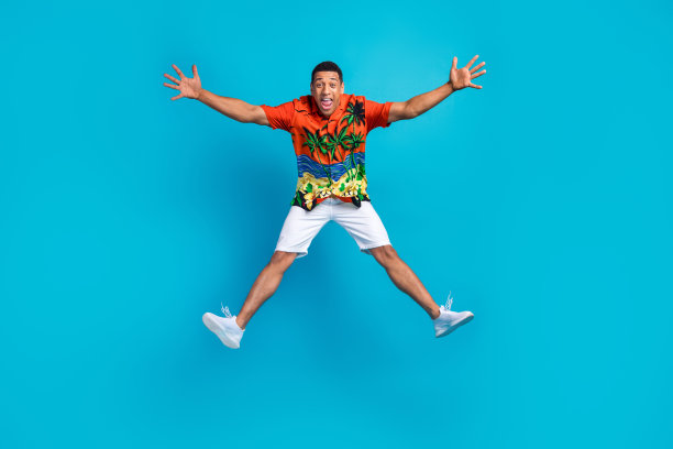 漂亮的年轻人的全身照片欢喜跳跃暑假孤立的蓝色背景图片下载