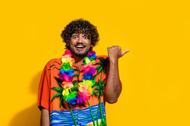 印象深刻的男人穿着印花衬衫花项链的照片表明，在令人敬畏的提供空白空间孤立的黄色背景图片下载