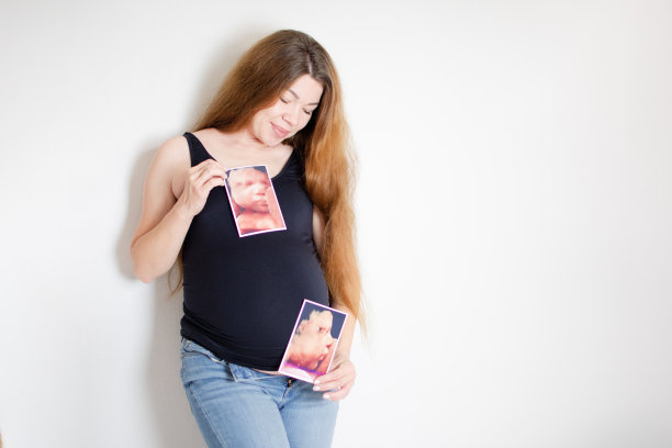 孕36周的孕妇拿着宝宝的3d超声照片。快乐的怀孕。健康的怀孕图片下载