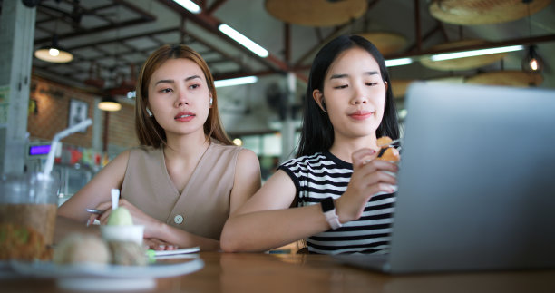 一位年轻女子在咖啡店工作时吃着冰淇淋。图片下载