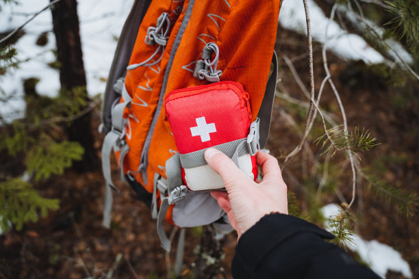 一个急救箱是用背带固定在背包的一侧，一个小的旅行急救箱，在森林里徒步旅行的设备。图片下载