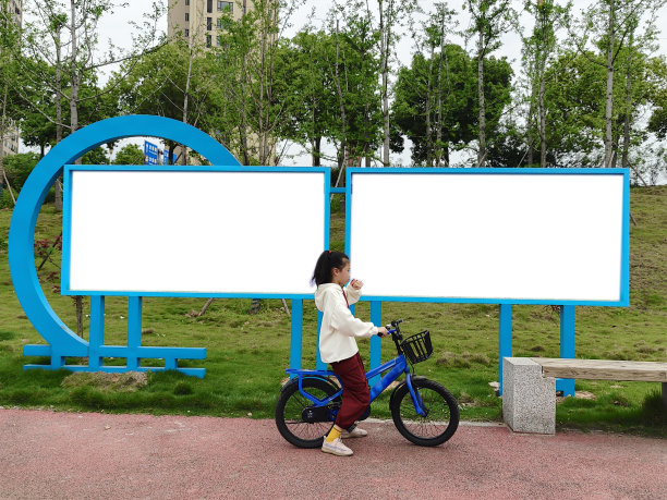 一个小女孩用智能手表在LED广告屏下说话图片下载