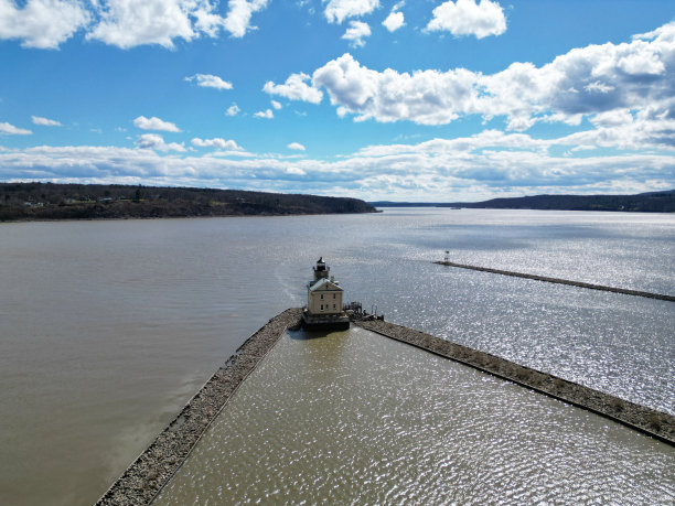 哈德逊河上的小灯塔，在水中有石线海堤(云山白天无人机从上面拍摄的照片)摄影景观灯塔，用于船只金斯顿ny图片下载