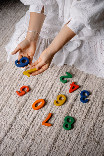 年轻女子手里拿着五颜六色的木制数字图片下载