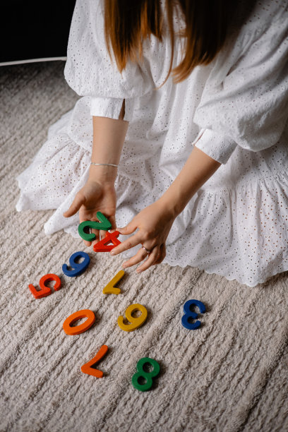 年轻女子手里拿着五颜六色的木制数字图片下载