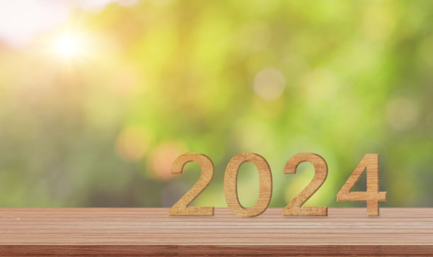 木质桌子上的2024号木牌，绿色自然背景。新的一年概念开始图片下载