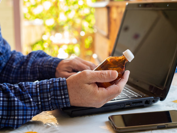 老人手里拿着一瓶药。医学的概念图片下载