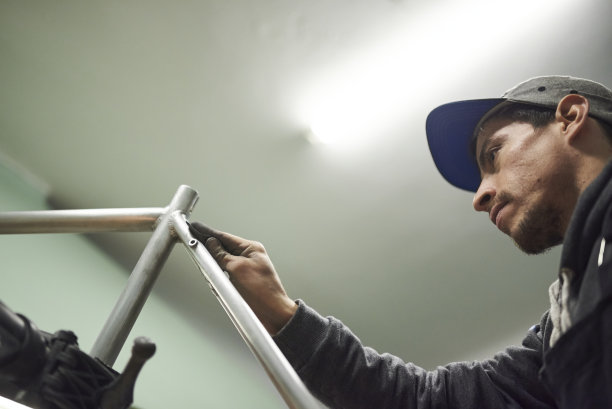 拉丁人在车间打磨自行车车架。有拷贝空间的合成。图片下载