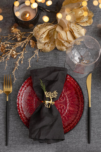 新年和圣诞节餐桌摆设近。圣诞餐桌上的红色空盘子和亚麻餐巾，垂直照片图片下载