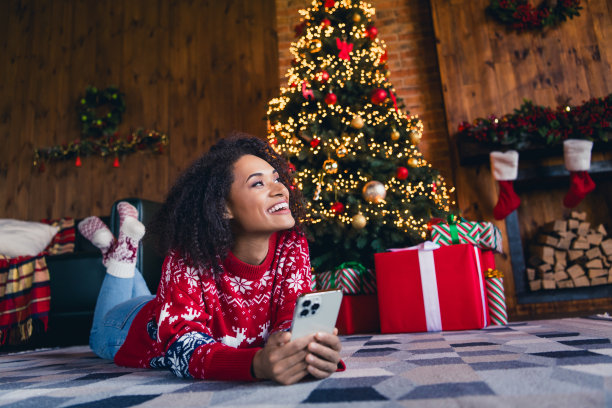 照片迷人可爱的梦幻女孩穿着圣诞红色套头衫躺在地毯上舒适的房间享受神奇的季节室内装饰的家图片下载