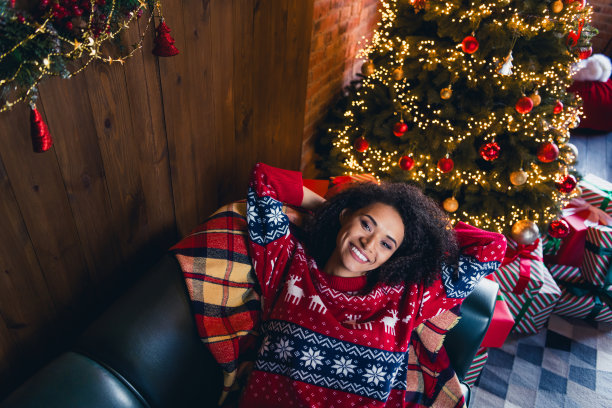 可爱的开朗开朗的女孩躺在舒适的沙发上装饰常青树的照片寒假舒适的神奇季节室内图片下载