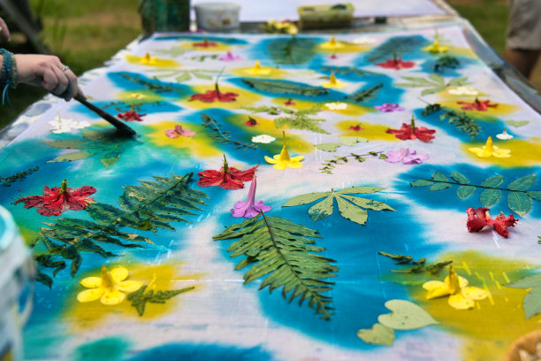 在塞舌尔马埃岛的车间里，皮肤白皙的妇女用布油墨在树叶上作画图片下载