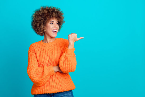 照片中开朗可爱的可爱女孩穿着时髦的衣服拇指介绍空白空间孤立的蓝色背景图片下载