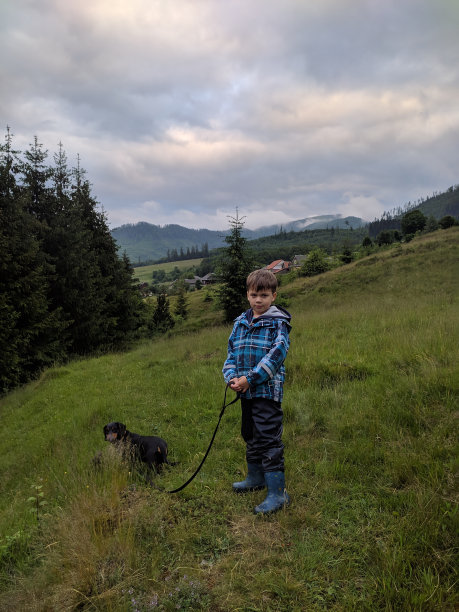 一个男孩和一只腊肠狗在森林里散步。照片。图片下载