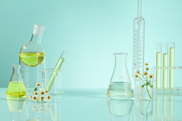 淡蓝色的背景有一些实验室的眼镜，里面有小白菊提取物液体。照片可用于天然成分制作的产品广告，空白空间用于文字或展示产品图片下载