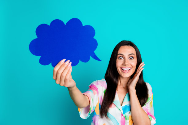 照片上惊奇的欣喜可爱的女人穿着时髦的印花衣服，手拿着卡片，空白的空间孤立在青色的背景上图片下载