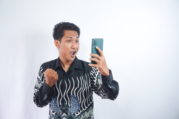 照片上，一个积极兴奋的男人尖叫着，在白色的背景下看手机图片下载