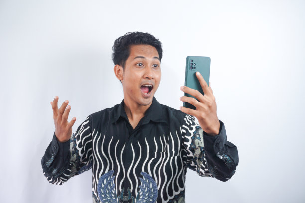 照片上，一个积极兴奋的男人尖叫着，在白色的背景下看手机图片下载