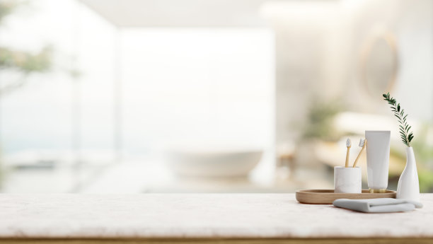 在带浴缸的现代浴室里，白色的桌面上放着牙膏、牙刷和毛巾。图片下载