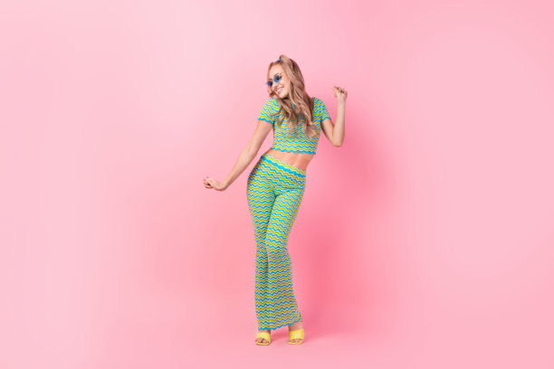 可爱的年轻女士假期舞会音乐会跳舞的全身照片穿着时髦的绿色印花服装孤立在粉红色的背景图片下载