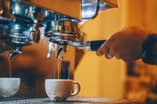 咖啡店专业咖啡冲泡。在温馨舒适的小咖啡馆里，咖啡师用咖啡机制作咖啡杯。图片下载