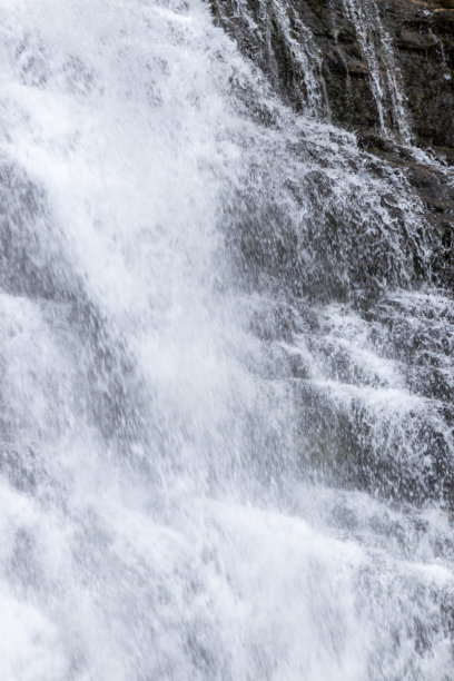 一个泡沫，白色的瀑布从黑暗，锯齿状的悬崖上倾泻而下的特写照片，ai生成图片下载