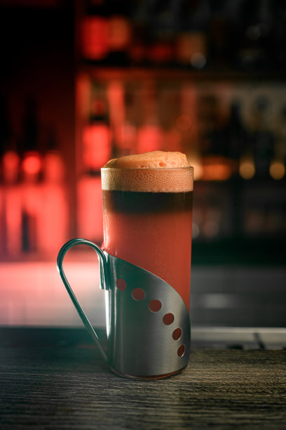 带金属支架的玻璃杯里装满了棕色泡沫饮料图片下载