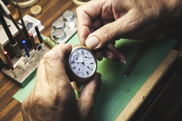 钟表匠对修好的表进行最后调整的手。图片下载