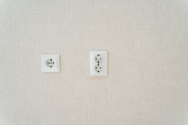 两个白色的电源插座安装在米色的墙上图片下载