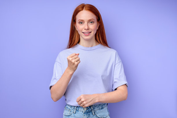 快乐的红发女孩用手势说话，握紧拳头图片下载