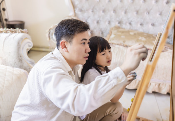 父亲和女儿在客厅里玩绘画游戏图片下载
