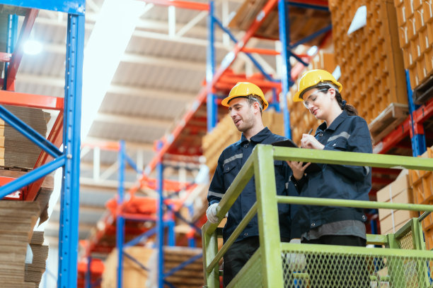 团队成员分析纸质物流清单，用笔记本电脑和剪贴板进行库存盘点，检查货架上的商品。根据订单计划生产出货。手持拍摄的。图片下载