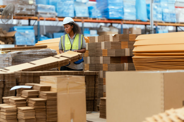 机器操作员在一家大型造纸厂工作，检查纸箱的库存。图片下载