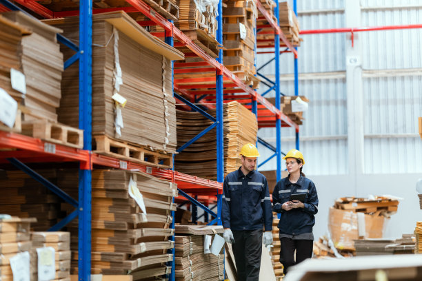 一家大型纸板厂的年轻员工在清点存货图片下载