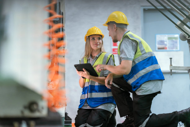 纸板箱制造工厂概念，工业工人使用机器在仓库储存或工厂生产中回收材料包装盒，用于全球物流业务图片下载