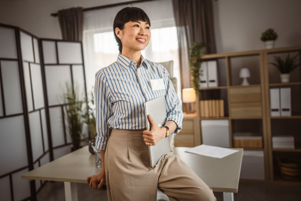 日本成熟女性在办公室拿着笔记本电脑的照片图片下载