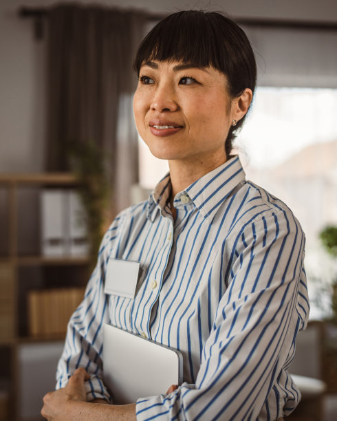 日本成熟女性在办公室拿着笔记本电脑的照片图片下载