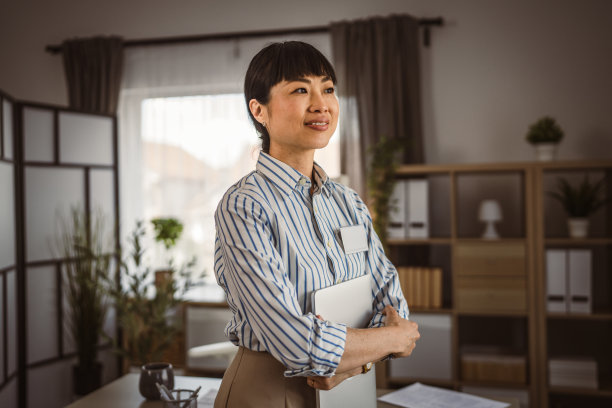 日本成熟女性在办公室拿着笔记本电脑的照片图片下载