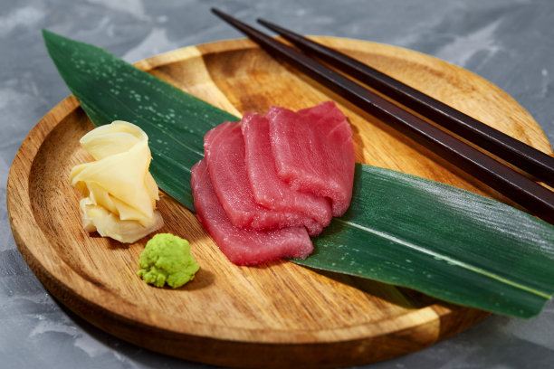 从上面看，金枪鱼片放在竹叶上，生姜和芥末被切碎，准备寿司。图片下载