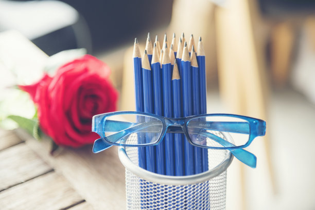 锐利HB蓝色铅笔银花瓶办公用品装饰咖啡杯玫瑰在木桌上。绿色装饰家庭办公桌。木质办公桌磨刀蓝2B铅笔盒家庭办公装饰桌图片下载