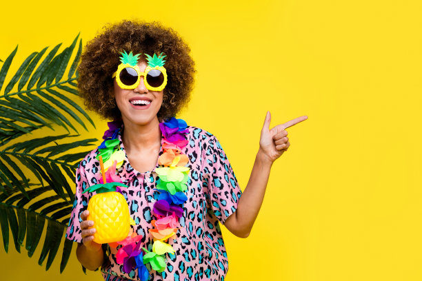 照片的梦幻漂亮的女士穿着豹纹衬衫，太阳镜享受果汁指向空白空间孤立的黄色背景图片下载